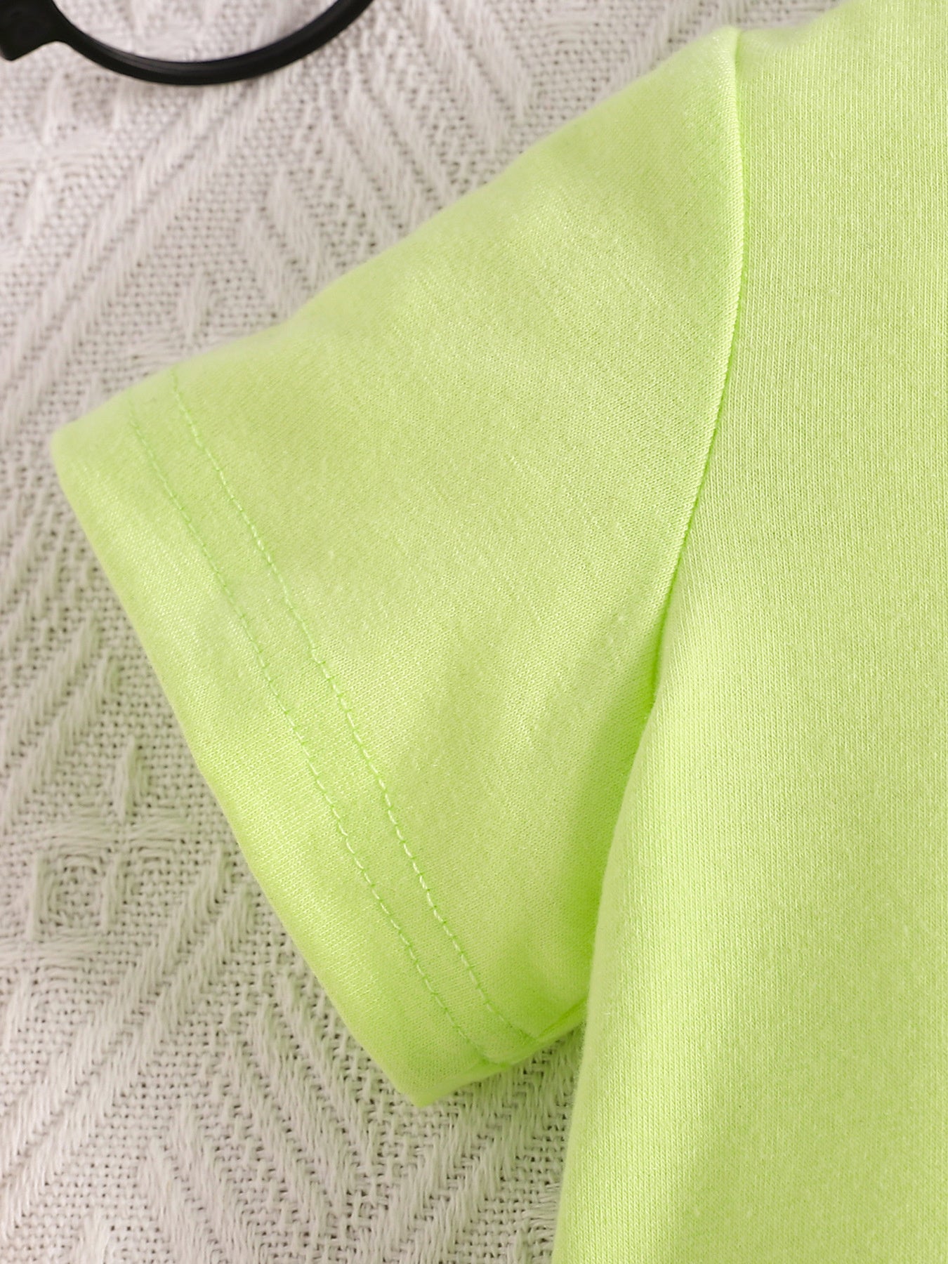 Children's lime green short sleeve polo shirt detail