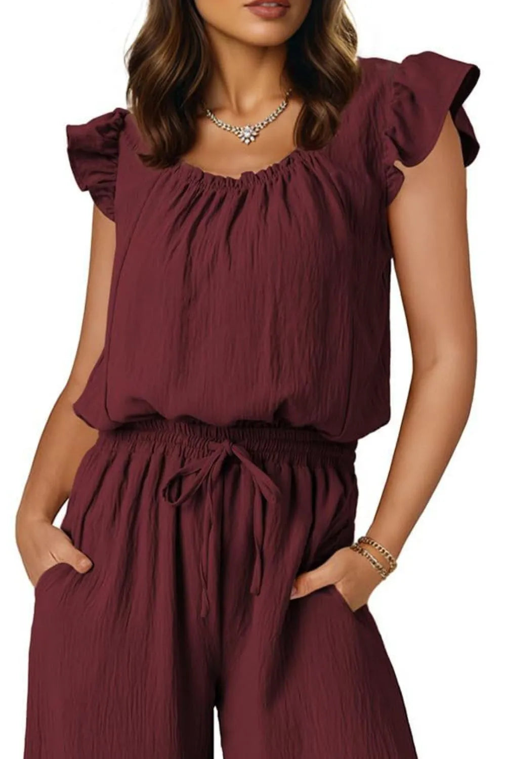 Burgundy textured drawstring palazzo jumpsuit with ruffle sleeves and square neckline.