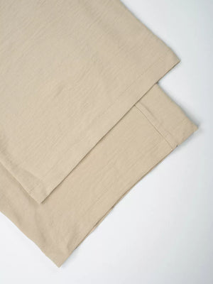 Tan maternity wide-leg pants with textured fabric and visible stitching detail.