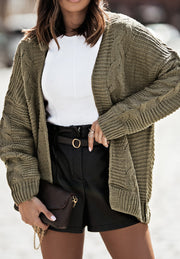 Olive cable knit open-front cocoon cardigan with textured sleeves.