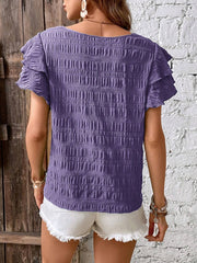 Purple textured smocked blouse with ruffle sleeves.