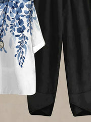 White half sleeve top with blue floral print and black pants.