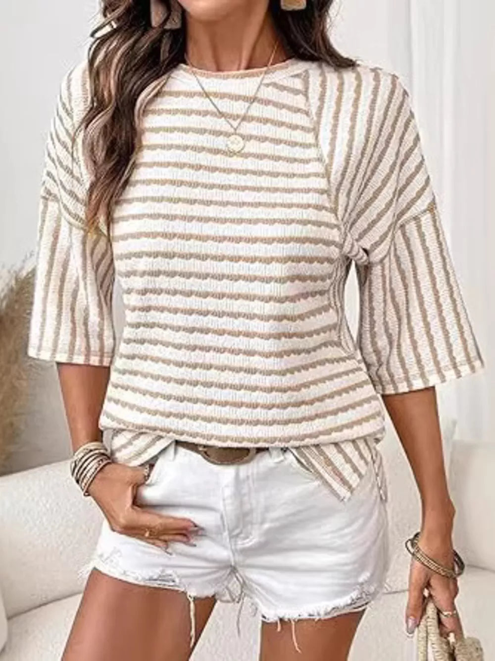 Wavy stripe knit t-shirt with relaxed fit and 3/4 sleeves in a beige and white stripe pattern.