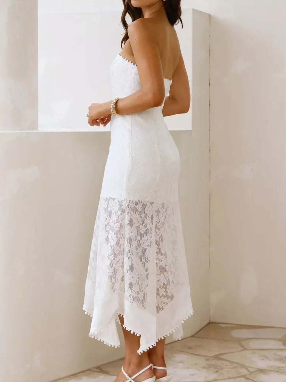White lace strapless midi dress with floral overlay and pom-pom trim hem