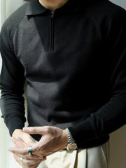 Black knit polo with zip-through neckline and raglan sleeves.