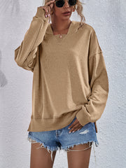 Tan boxy hooded sweatshirt with split hem and v-neck detail.
