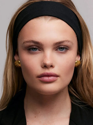 Gilded scallop ear studs in gold, featuring a textured, shell-like design.