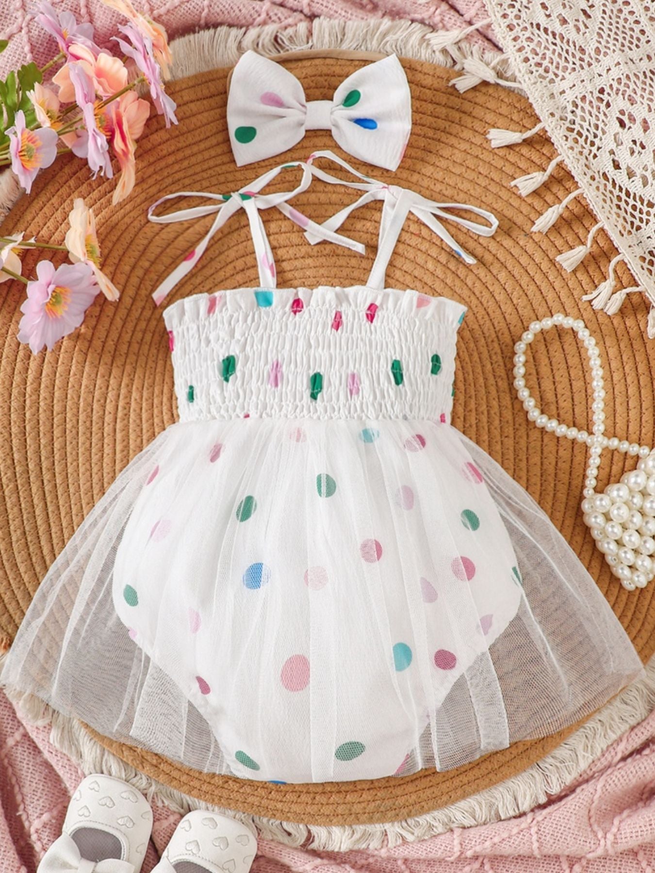 White smocked bodysuit dress with colorful polka dots and tulle overlay, includes matching bow headband.