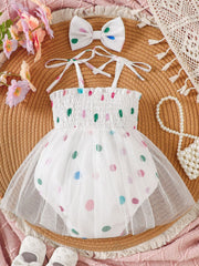 White smocked bodysuit dress with colorful polka dots and tulle overlay, includes matching bow headband.