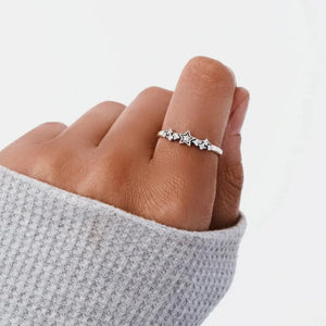 Silver band ring with a celestial cluster of stars and small stones.