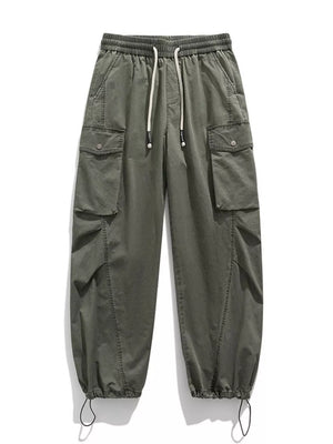 Green cargo pants with drawstring waist, button-down flap pockets, and adjustable cuffs.