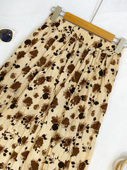 Botanical pleated midi skirt in tan with a crinkled texture and elastic waistband.