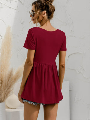 Burgundy V-neck tee with gathered waistline and short sleeves, styled with denim shorts.