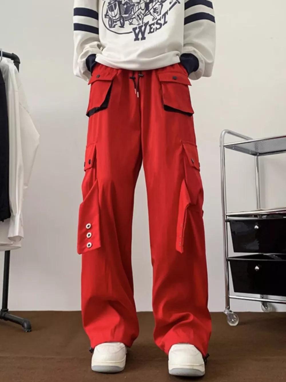 Men's red relaxed-fit cargo pants with multiple pockets and button details.