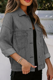 Pinstripe denim trucker jacket in dark with button front and chest pockets.