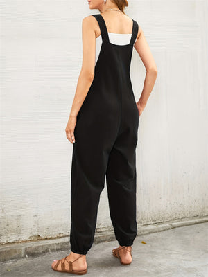 Black cotton overalls jumpsuit with a heart pocket detail and cuffed ankles.