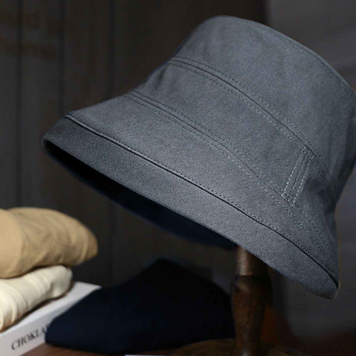 Dark gray cotton bucket hat with stitched details and a wide brim.