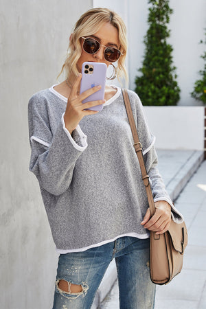 Oversized grey knit sweater with white contrast trim and V-neck