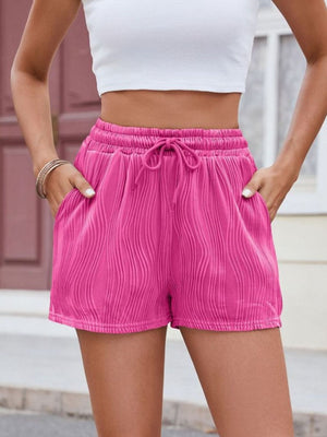 Hot pink textured wave drawstring shorts with pockets.