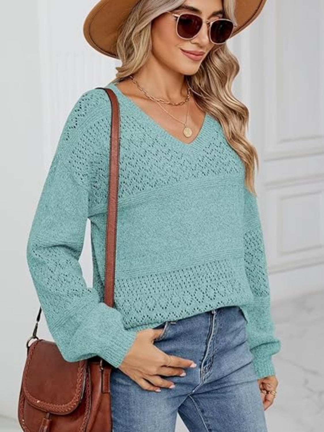 Turquoise V-neck sweater with diamond eyelet knit detail and long sleeves.