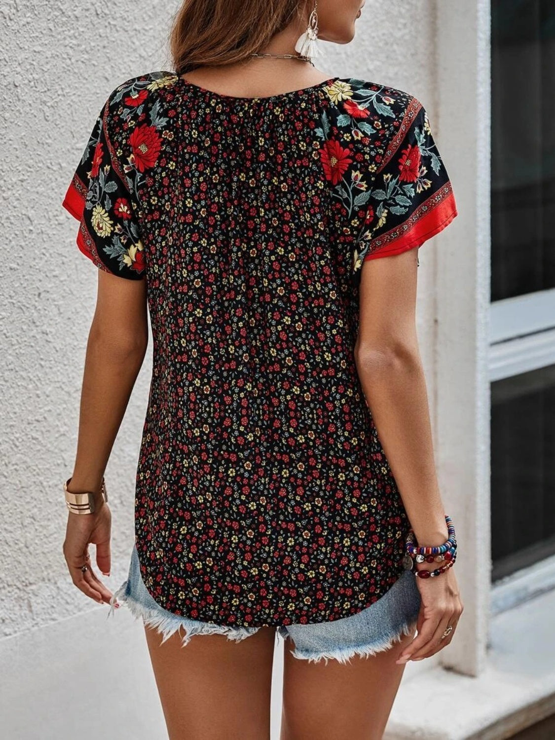 Bohemian floral print blouse with flutter sleeves and a split neckline in multicolor.