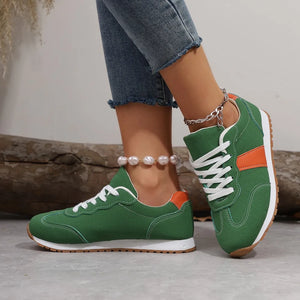 Green suede and canvas sneakers with orange accents and white laces.