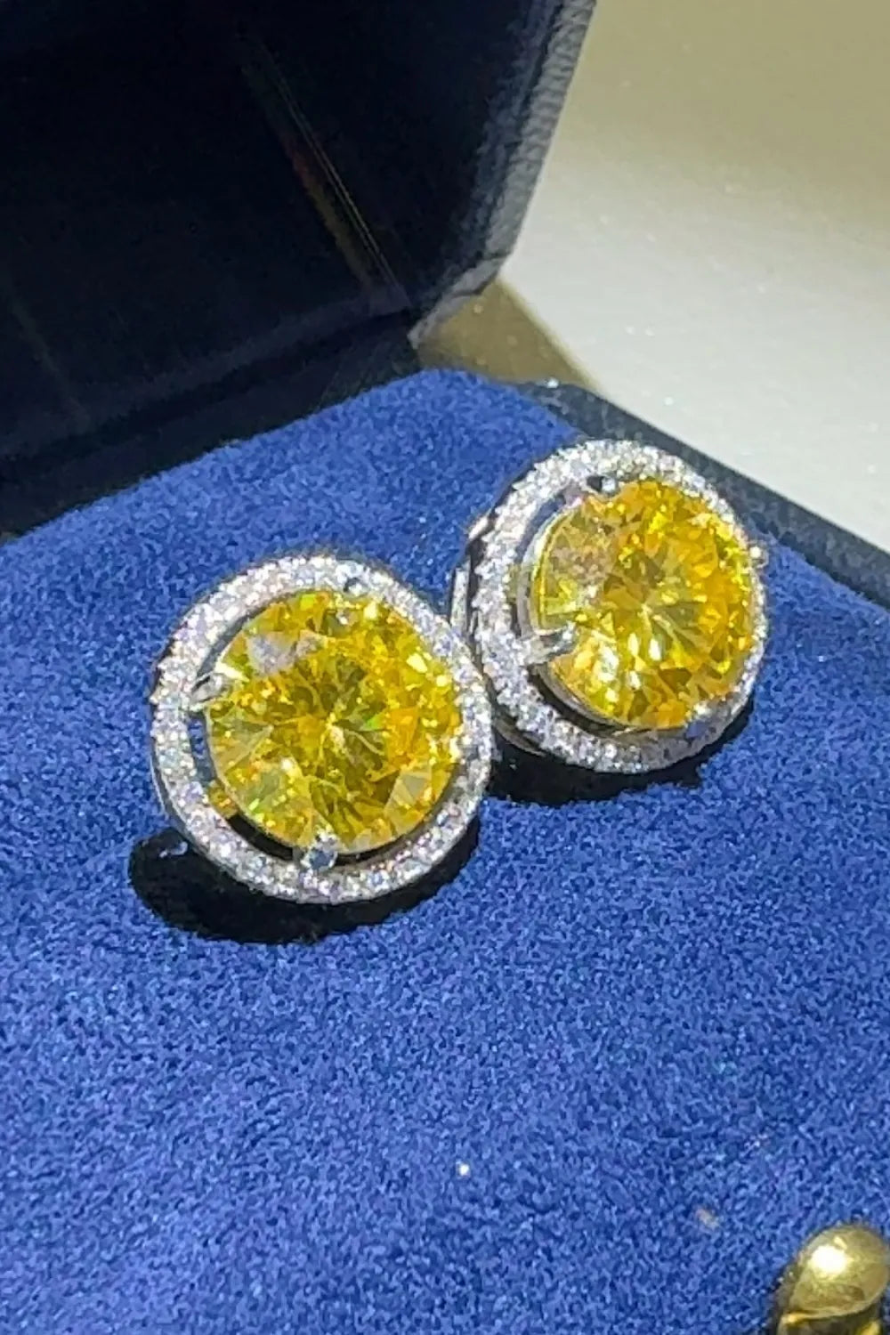 Canary yellow moissanite halo stud earrings with diamond accents.