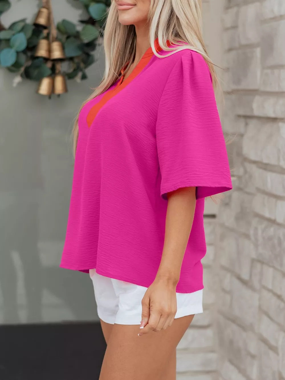 Textured hot pink V-neck blouse with orange trim and half sleeves.