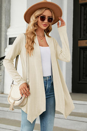 Cream textured knit cardigan with asymmetrical hem and open front.