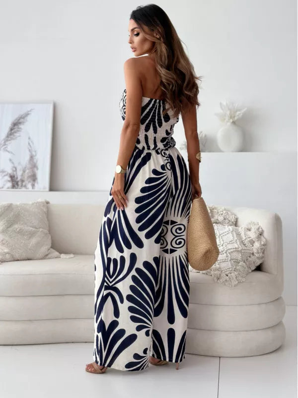 Strapless wide-leg romper in black with tribal print, smocked bodice, and flowy polyester fabric.
