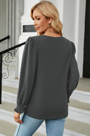 Dark gray ribbed cuff top with puff sleeves and ruffled cuffs.