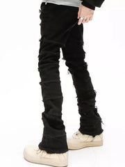 Black cotton jeans for men with frayed hem and distressed details.