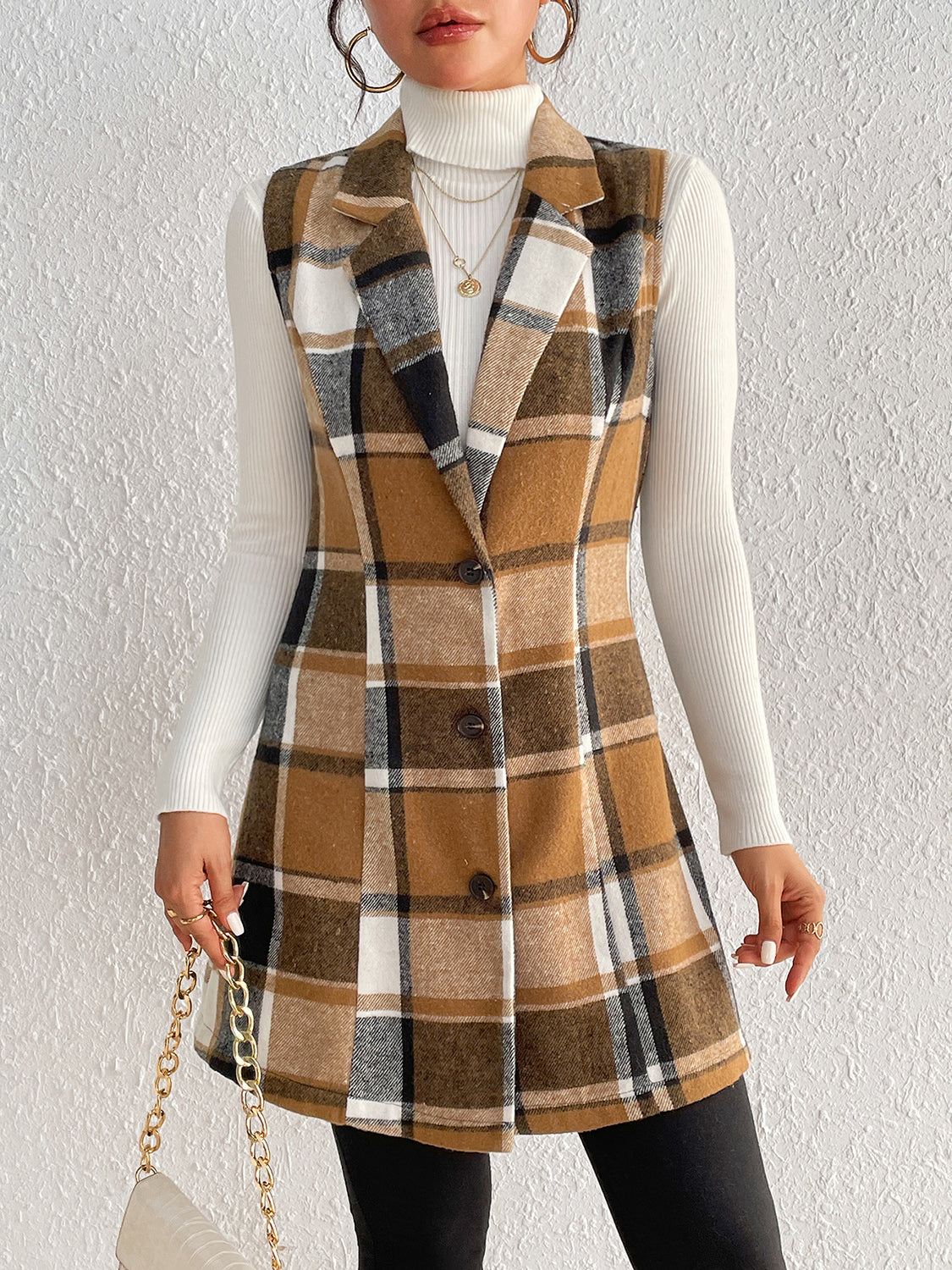 Camel plaid blazer vest with tailored silhouette and button front, worn over a white turtleneck.