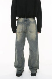 Vintage wash wide-leg jeans in dark gray with pleated detail and distressed accents.