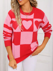 Red and blush pink checkerboard heart knit sweater with crew neck and long sleeves.