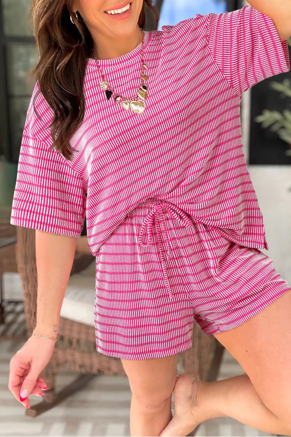 Fuchsia pink striped two-piece short set with drawstring waist and short sleeves.