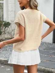 Apricot relaxed openwork knit top with short sleeves and a round neckline, styled with a white pleated skirt.
