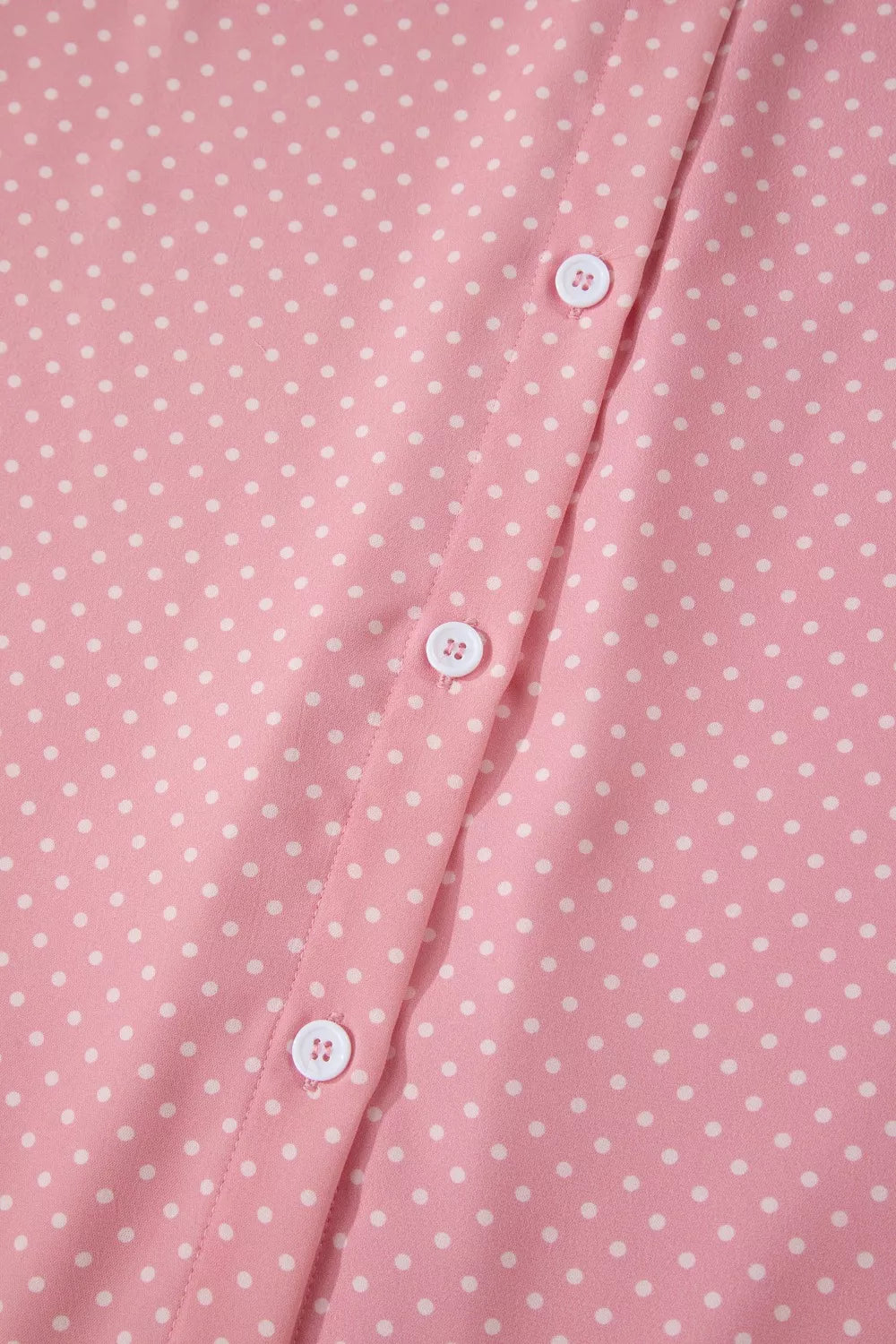 Pink polka dot print polyester button-up blouse with white buttons.