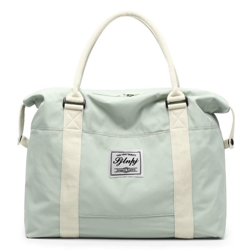 Light Green travel duffel bag with cream straps and a central logo patch.