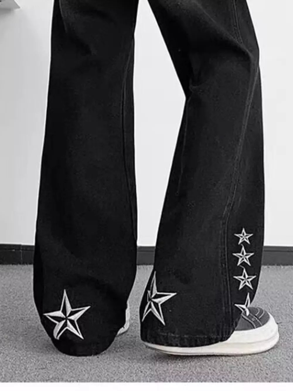 Black wide-leg jeans with embroidered white stars on the legs.