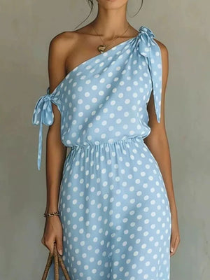 Sky blue polka dot maxi dress with one-shoulder neckline and tie details.