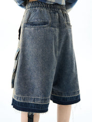 Blue denim cargo shorts with elastic waist and distressed hem detail.