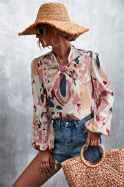 Abstract print pussy bow blouse with balloon sleeves and a tie neck detail.