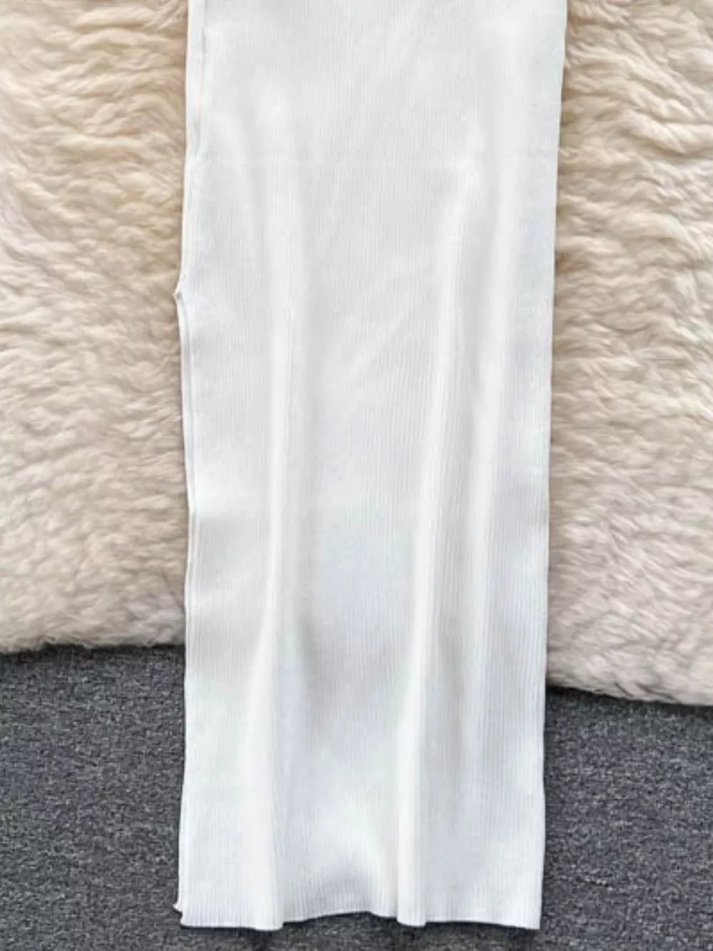 White ribbed knit midi dress with a bodycon fit and cutout detail.