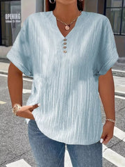 Light blue textured v-neck t-shirt with decorative buttons and cuffed short sleeves.