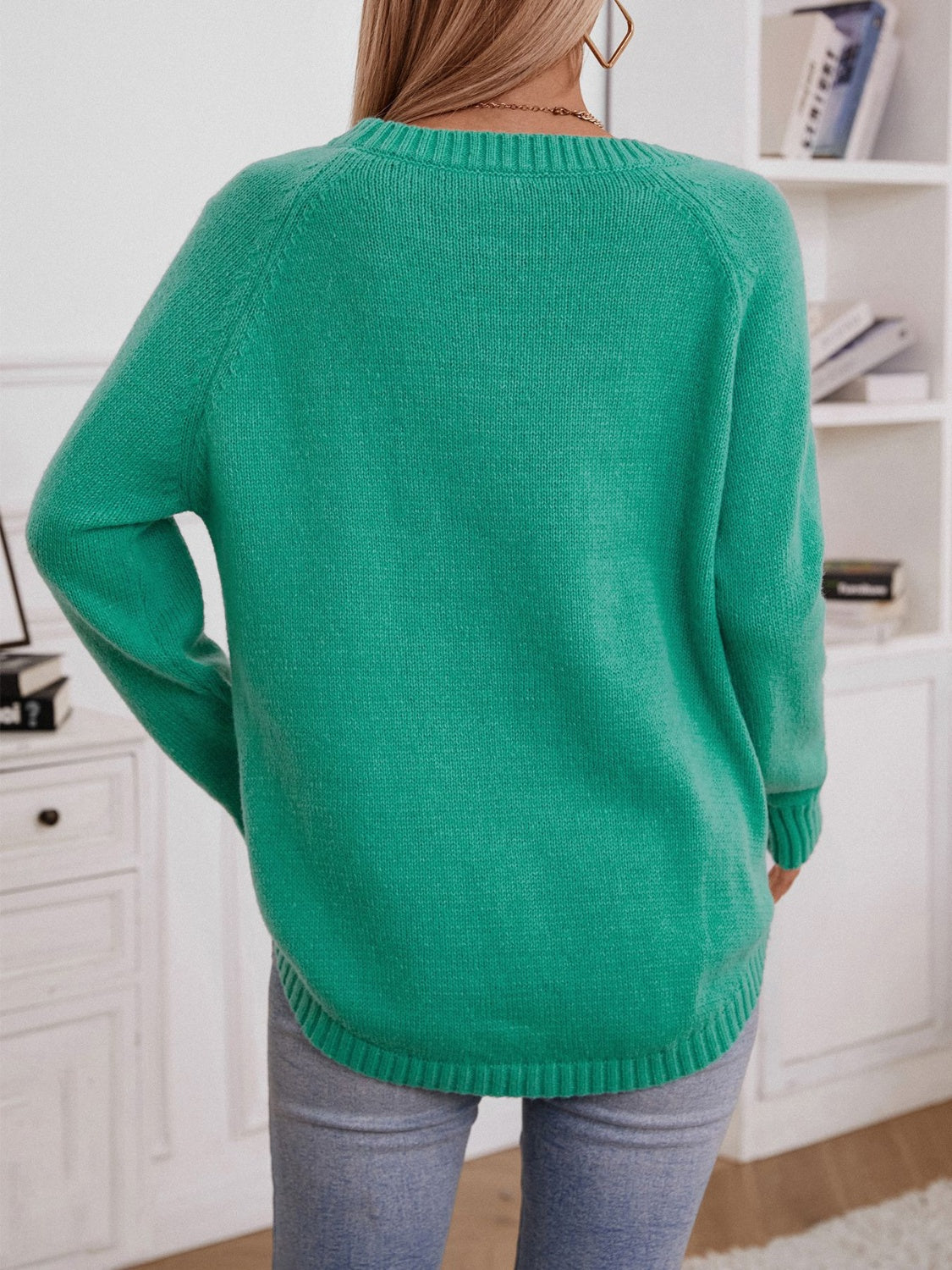 Green acrylic cable knit sweater with button shoulder detail and crew neck.