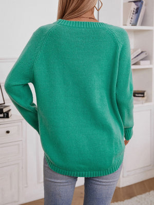 Green acrylic cable knit sweater with button shoulder detail and crew neck.