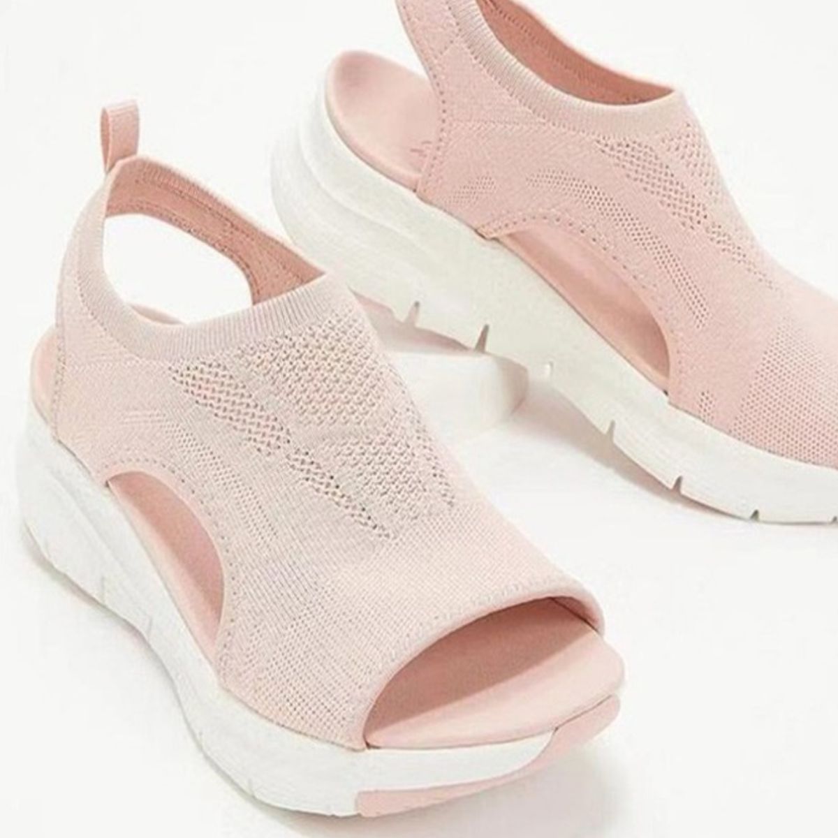 Pink breathable open-toe wedge sandals with a chunky white sole and knit upper.