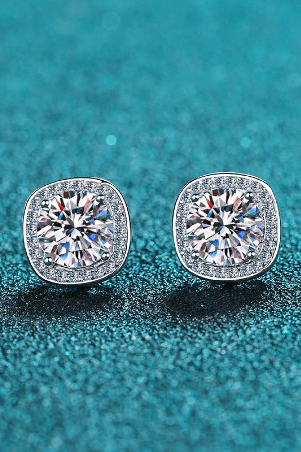 Silver cushion cut halo moissanite stud earrings with sparkling accents.