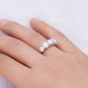 Silver band ring with five round moissanite stones.